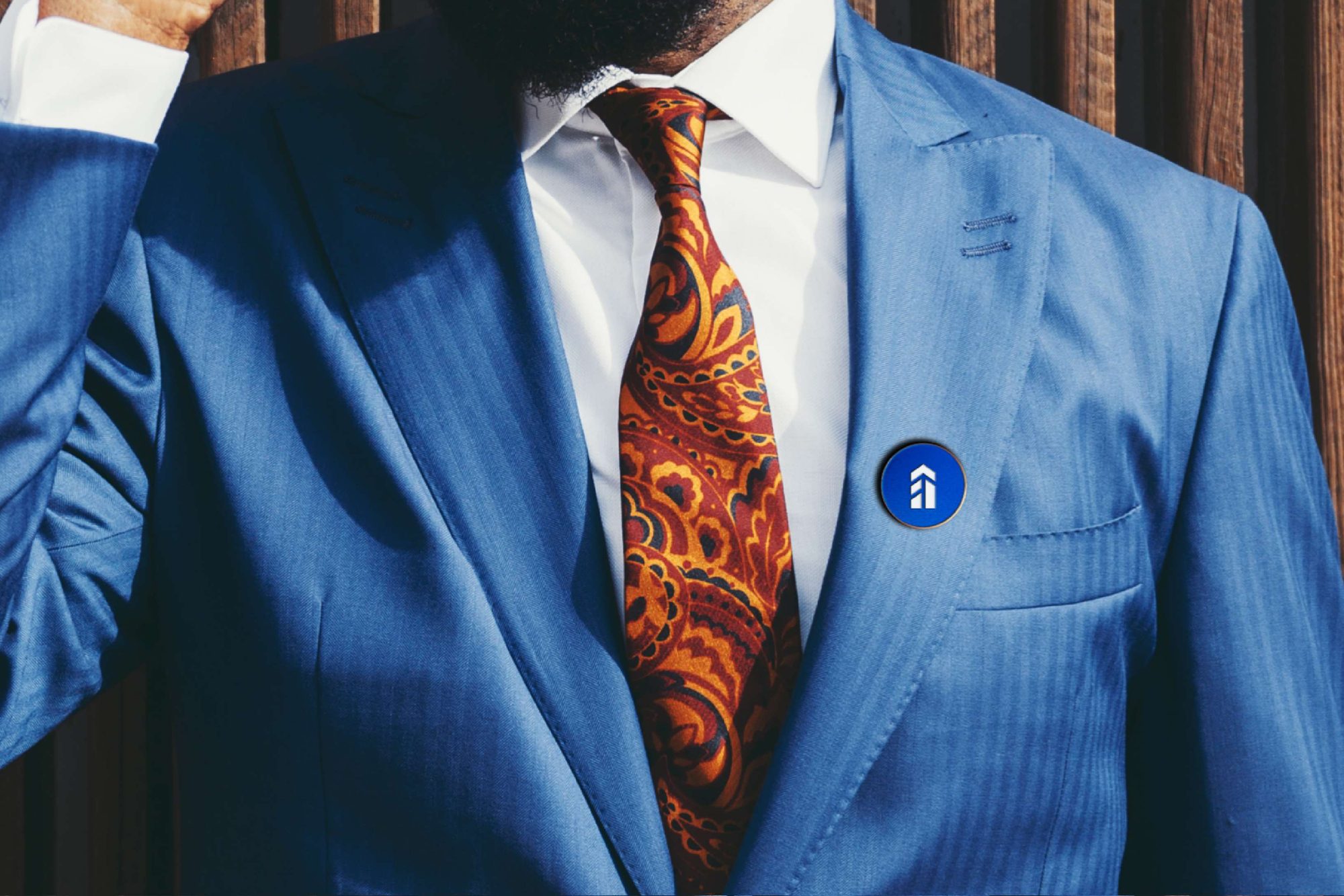 Close-up of a blue suit with a First Row Associates lapel pin