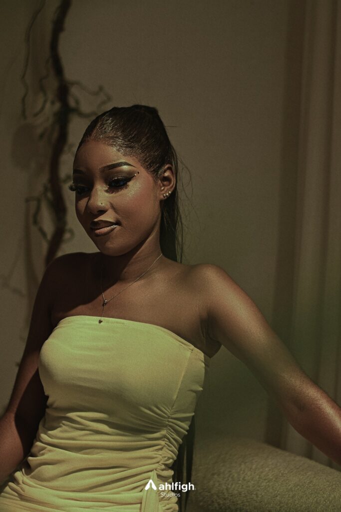 Nikki seated in low green light, looking down