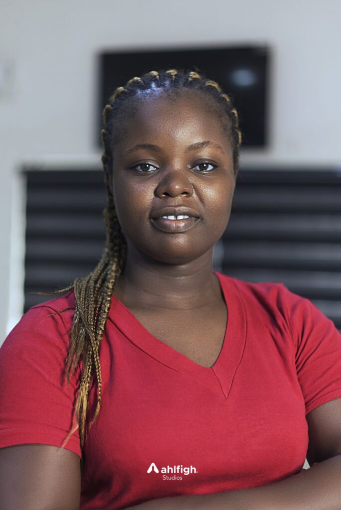 Carlos staff portrait: a red top, braids over one shoulder