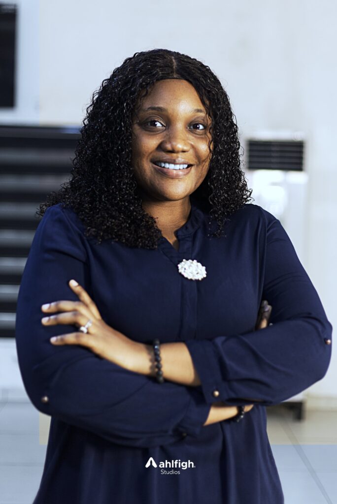 Carlos staff portrait: curly hair and navy, arms crossed
